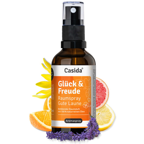 Glück & Freude raumspray bottle with a black spray top, surrounded by citrus fruits and lavender flowers.