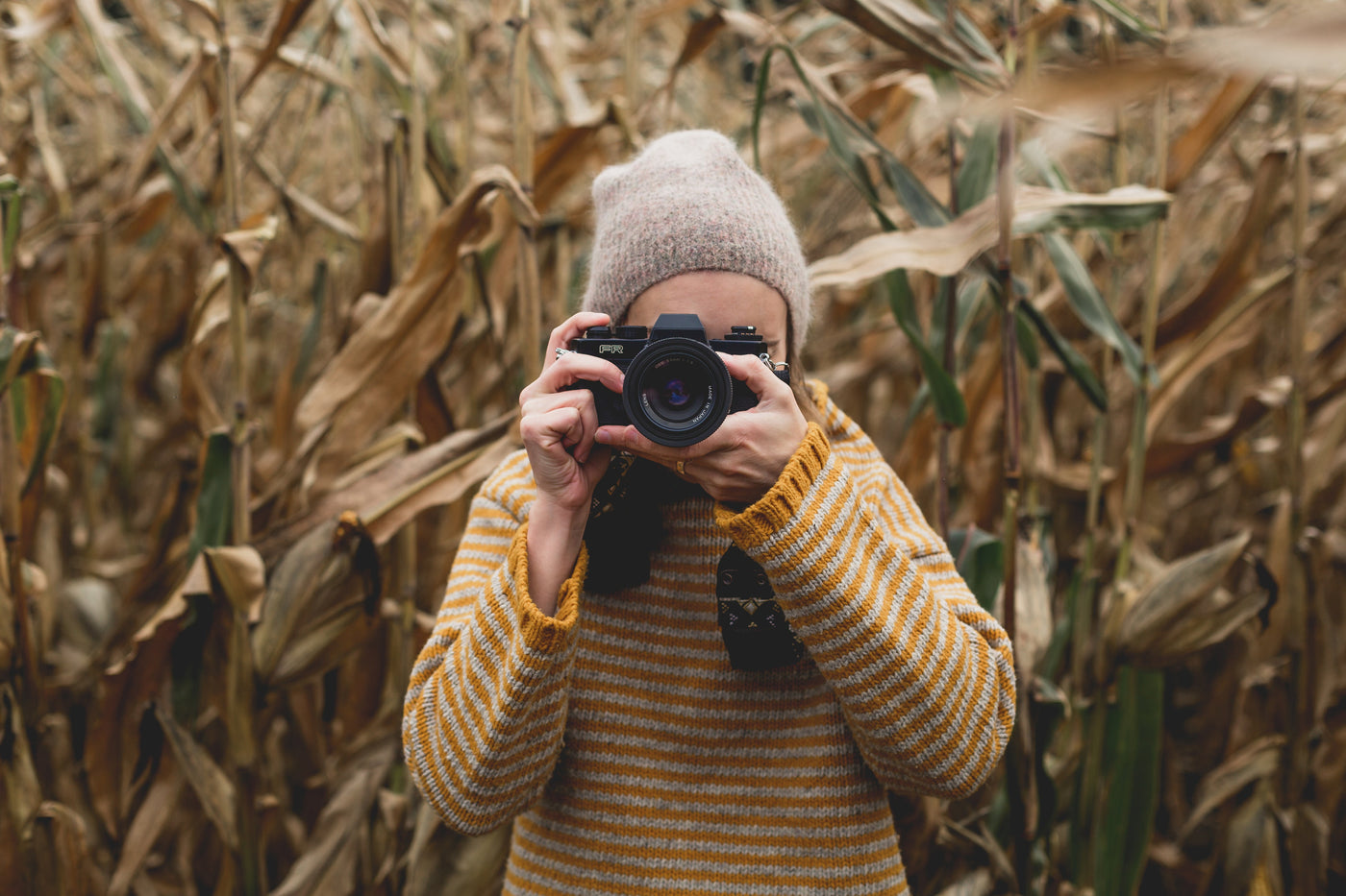 Fotografin steht im Feld und fotografiert Betrachter