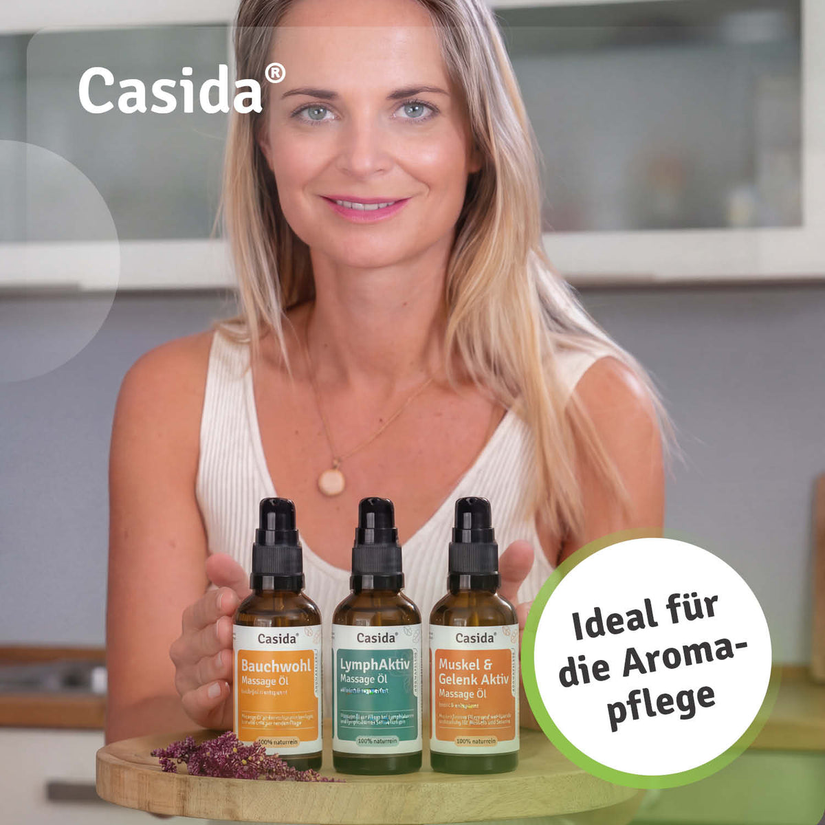 Basis Set Aromapflege includes three massage oils: Bauchwohl, LymphAktiv, and Muskel & Gelenk Aktiv on a wooden tray.