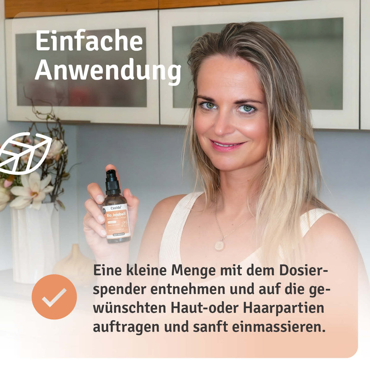 Jojobaöl in einer braunen Flasche mit Spender, präsentiert von einer Frau in einem hellen Raum.
