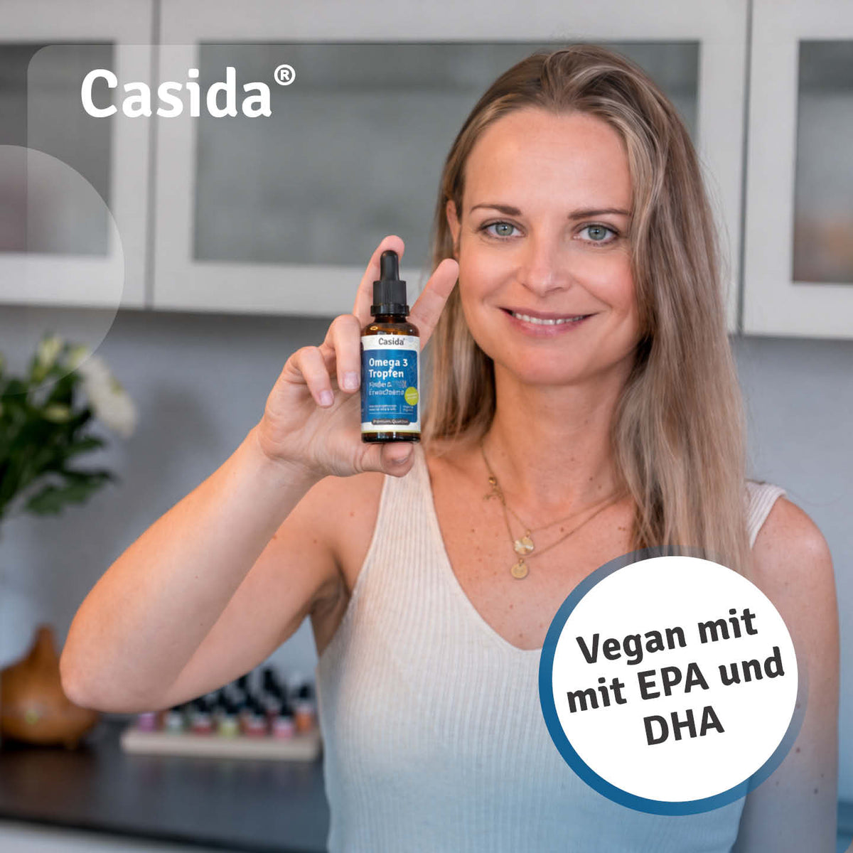 Frau präsentiert eine Pipettenflasche Casida Omega 3 Tropfen