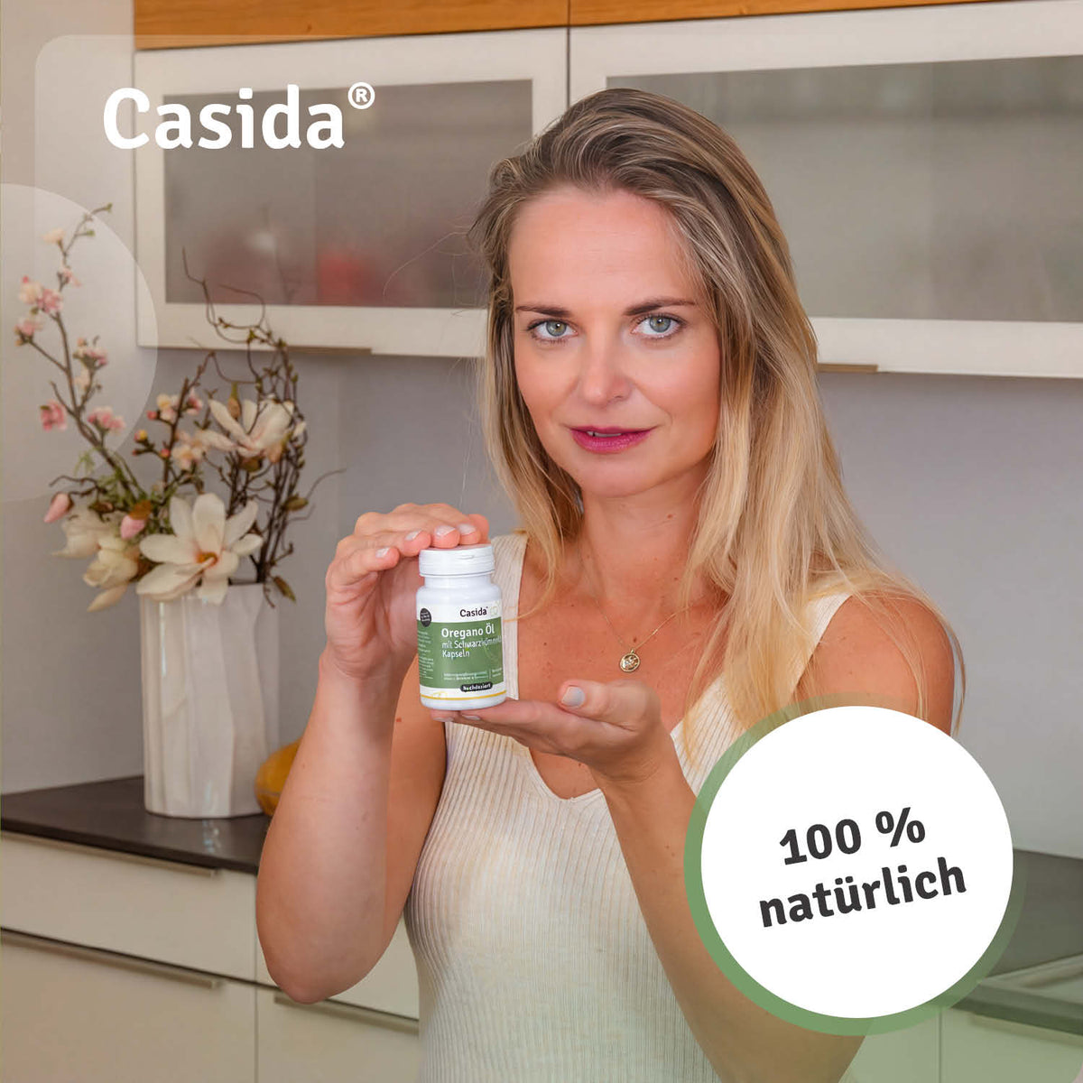 Frau präsentiert eine Dose Casida Oregano-Öl mit Schwarzkümmelöl Kapseln