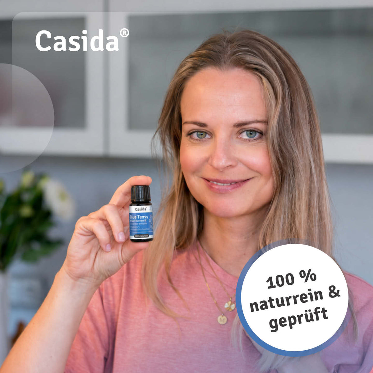 Frau präsentiert eine Flasche Casida Blue Tansy Blauer Rainfarn Öl