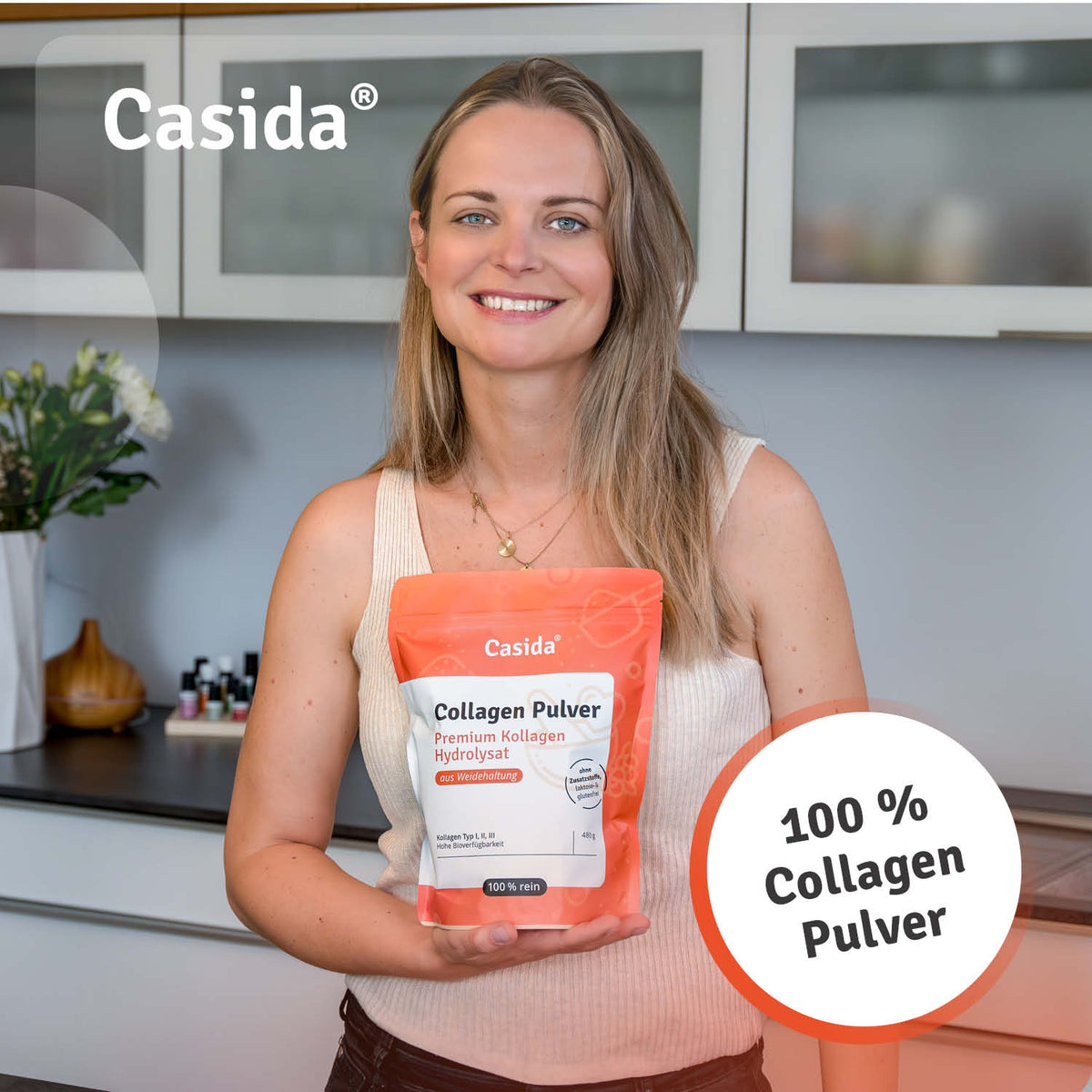 Collagen Pulver in an orange bag held by a woman, featuring a kitchen background and product details on the label.
