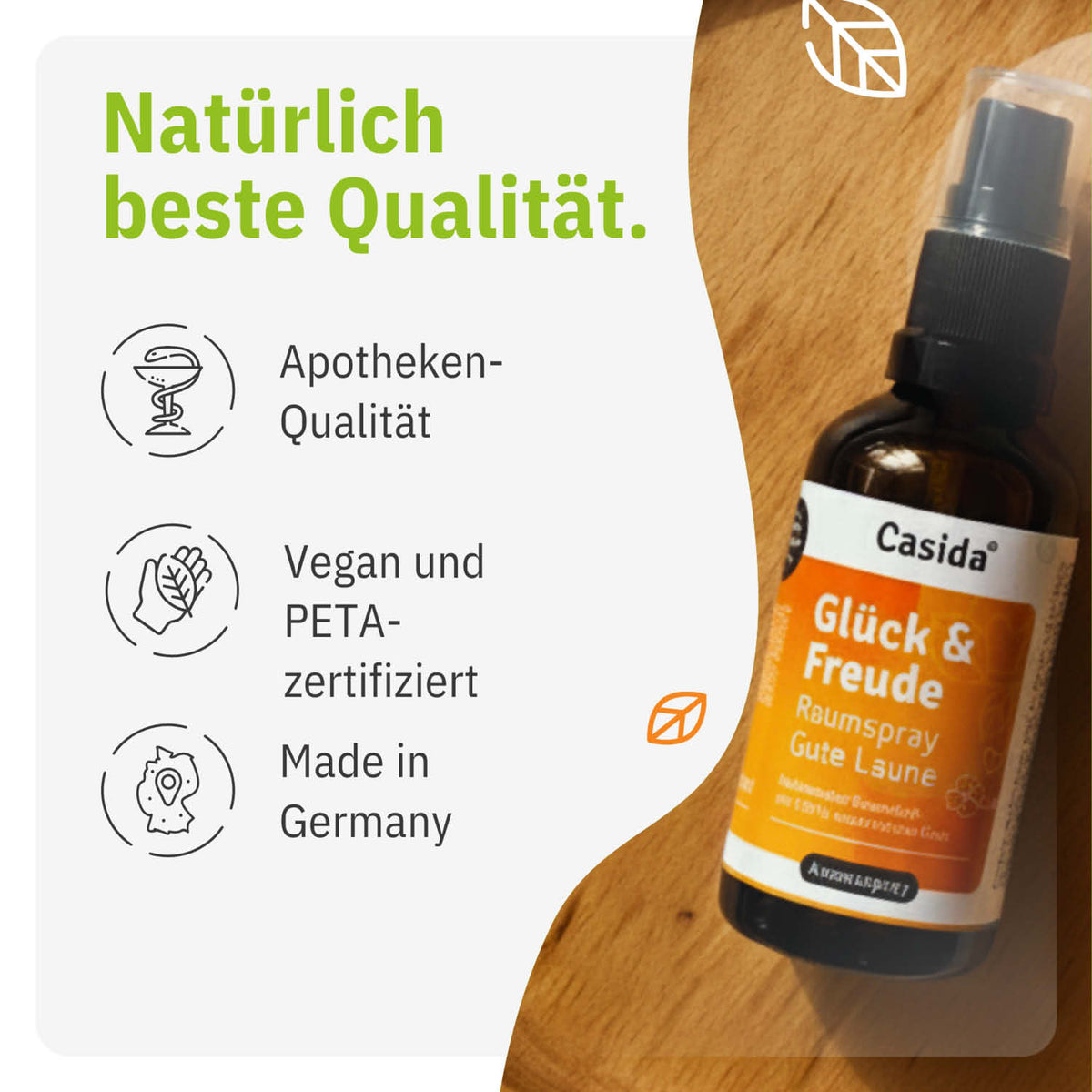 Glück & Freude raumspray bottle with a black spray nozzle, featuring orange and white labeling, on a light background.