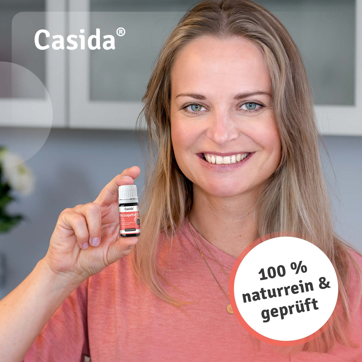 Frau präsentiert eine Flasche Casida Bio Grapefruitöl