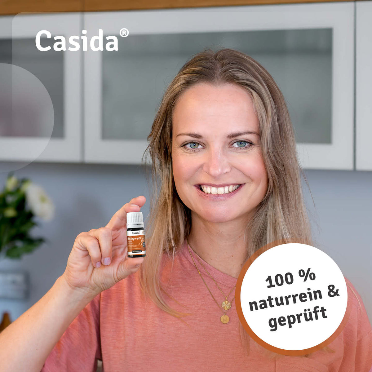 Frau präsentiert eine Flasche Casida Bio Ingweröl