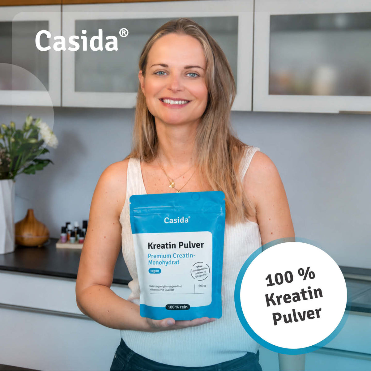 Frau präsentiert einen blauen Beutel Casida Kreatin Pulver