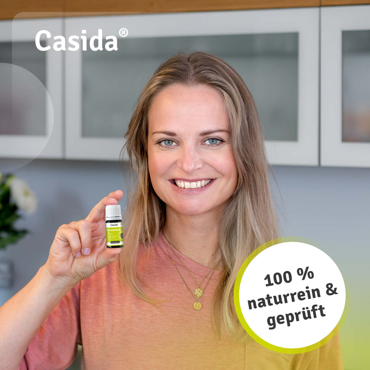 Frau präsentiert eine Flasche Casida Bio Limettenöl