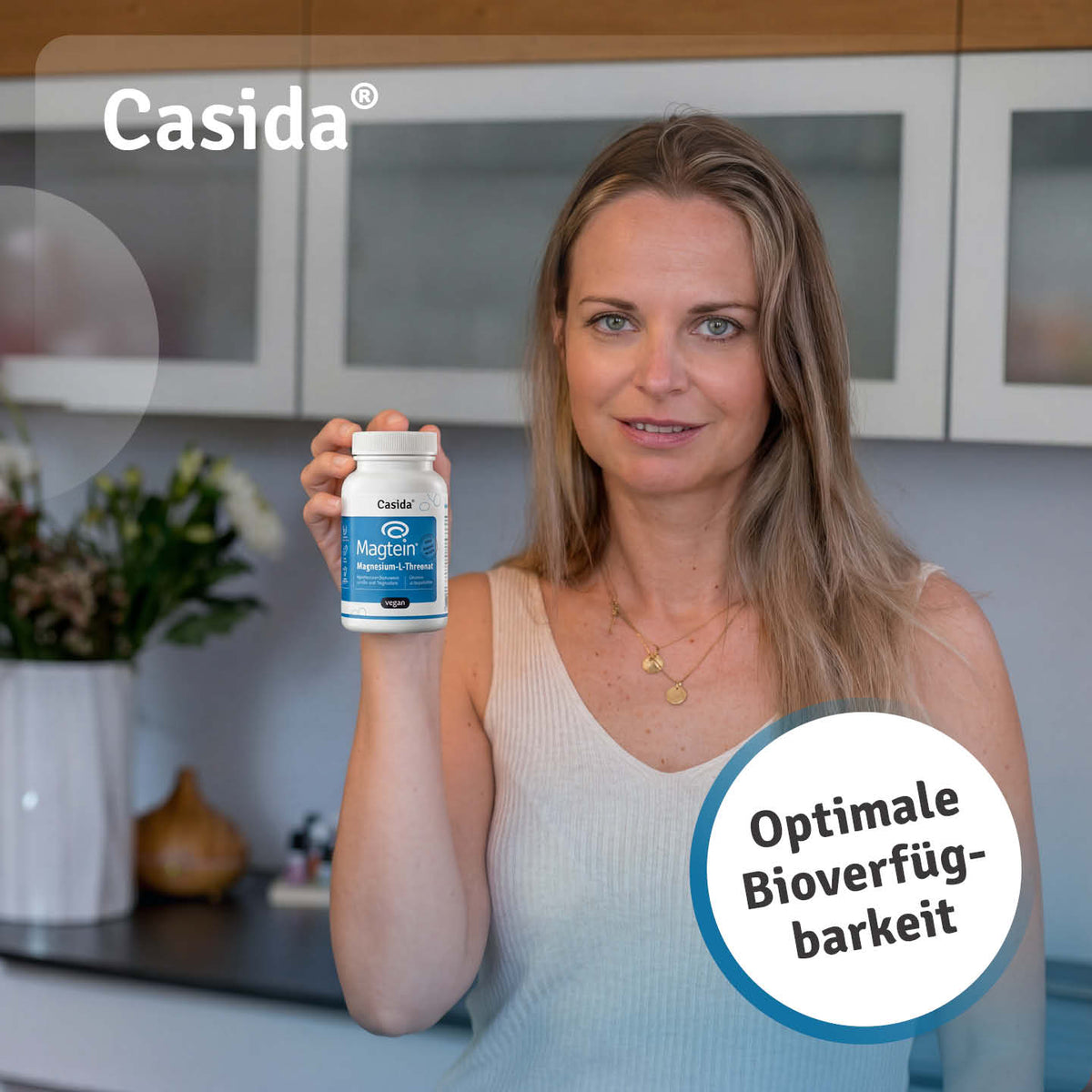Frau präsentiert Casida Magtein Magnesium-L-Threonat Kapseln in einer weißen Dose