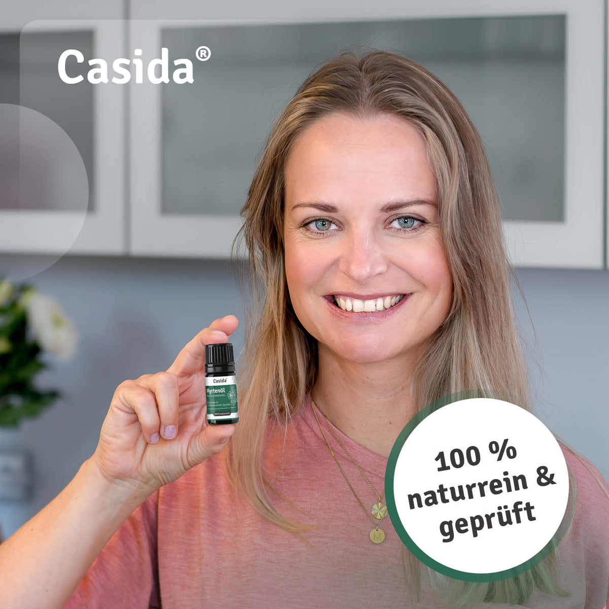Frau präsentiert eine Flasche Casida Myrtenöl