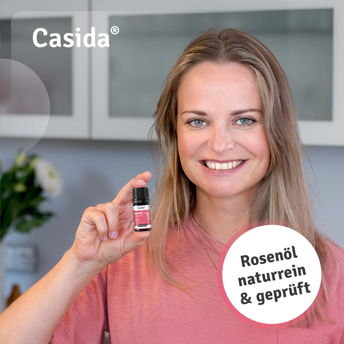 Frau präsentiert eine Flasche Casida Rosenöl 5 %