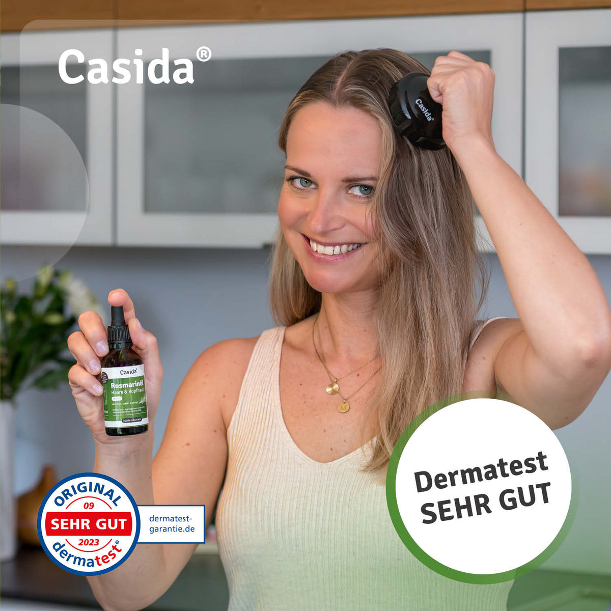 Casida rosmarinöl for hair and scalp in a dropper bottle, held by a woman in a light tank top, with a kitchen background.