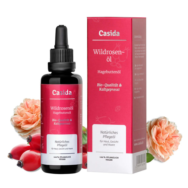 Casida wildrosenöl in a 50 ml dropper bottle with a red and white label, accompanied by pink rose flowers.