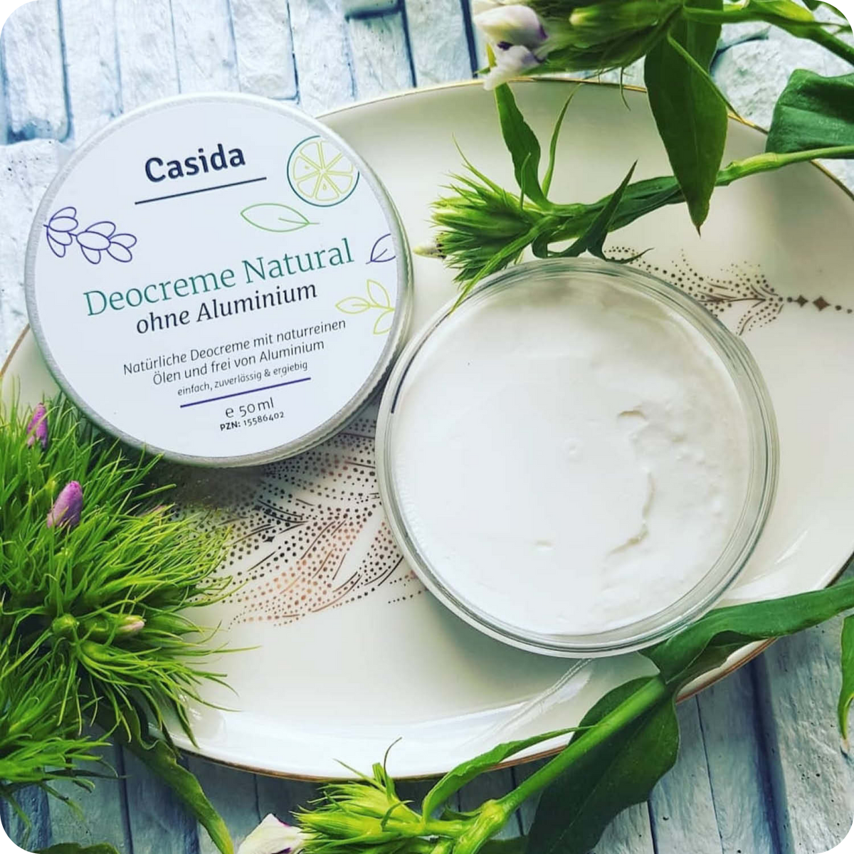 Casida Sommer Set featuring a natural deodorant cream in a round container with green plant accents.