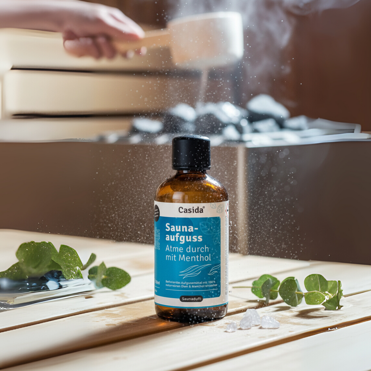 Saunaaufguss Atme durch mit Menthol oil in a brown bottle on a wooden table, with sauna stones and eucalyptus leaves nearby.