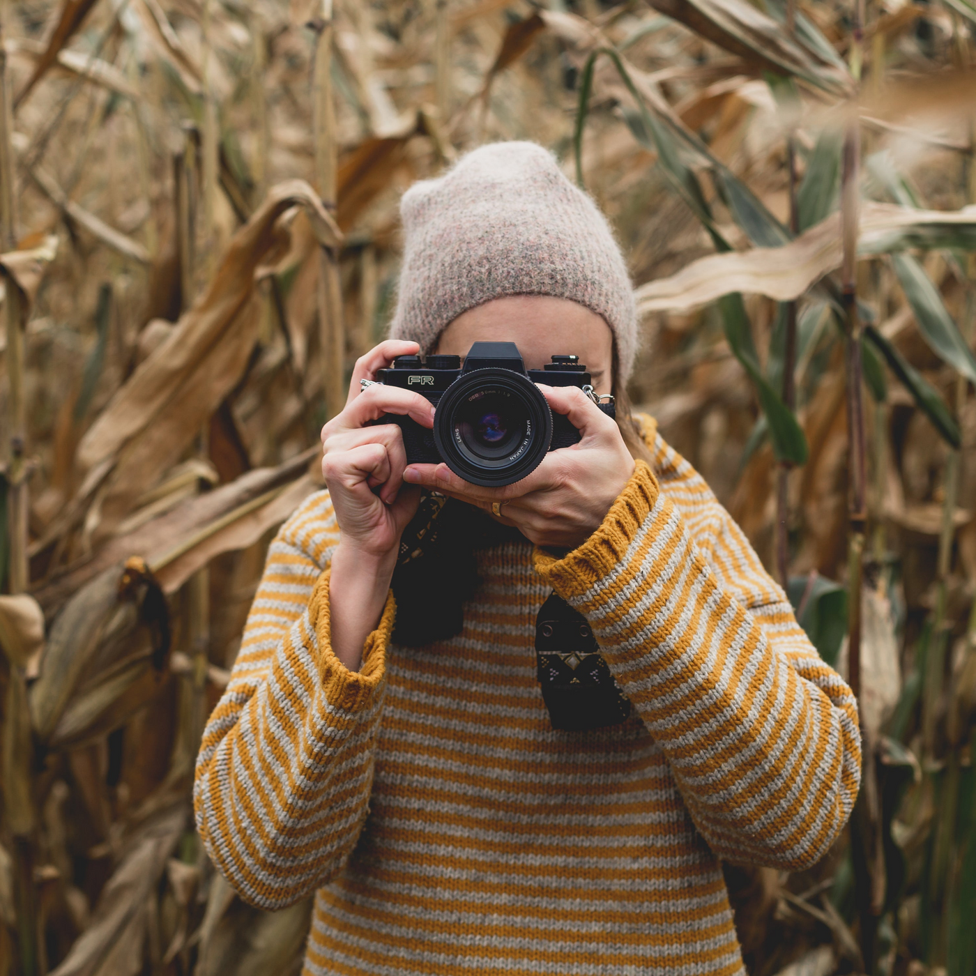 Fotografin steht im Feld und fotografiert Betrachter